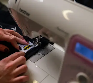 branded neck label being sewn into a black t-shirt.