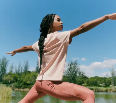 a person doing a yoga pose wearing stanley stella t shirt and leggings.