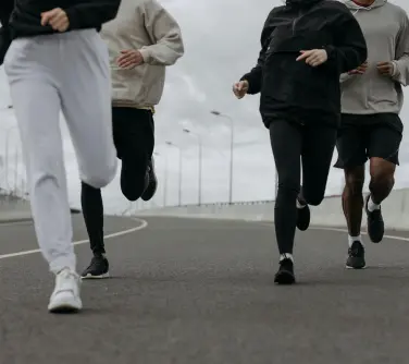 People running wearing different variations of activewear including tracksuit bottoms, hoodies and jackets.
